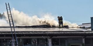 Die Feuerwehrleute versuchen das Feuer vom Dach aus zu löschen.
